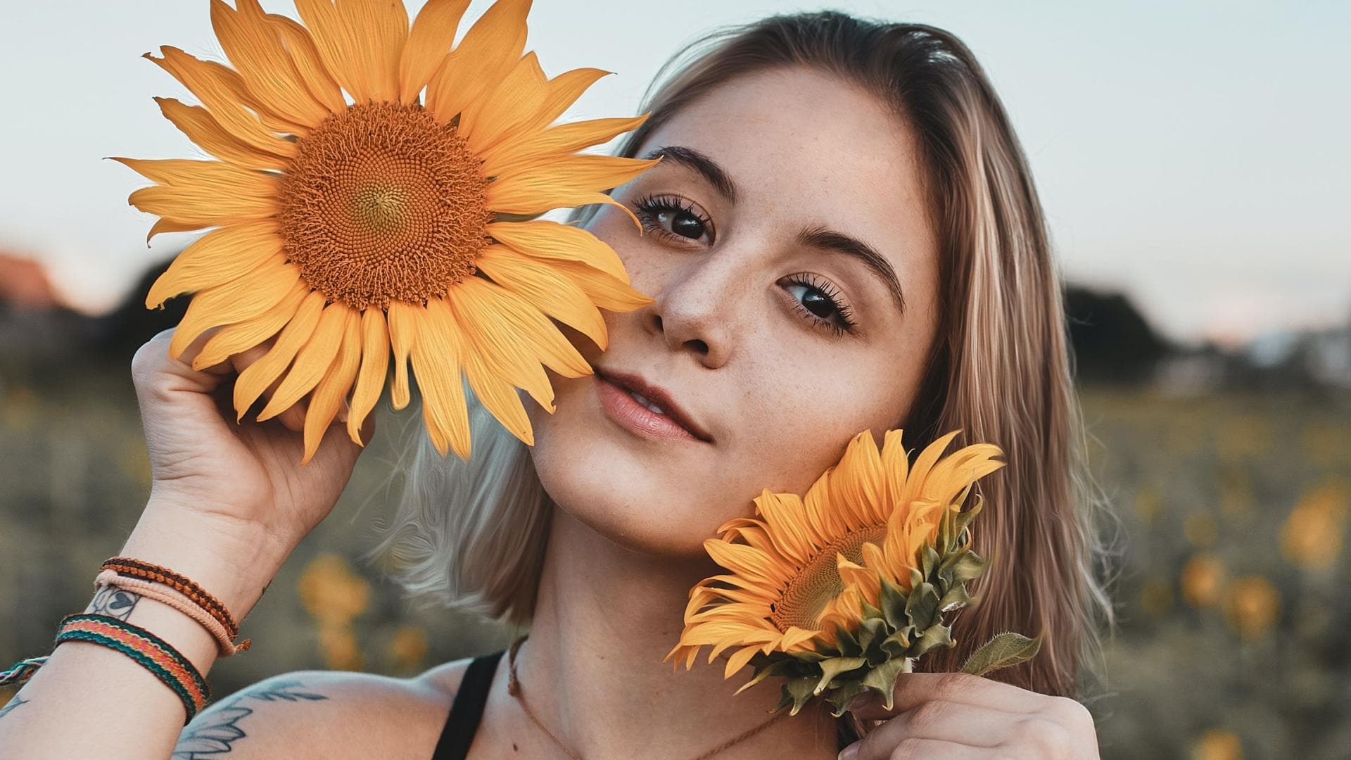 Mädchen auf einem Feld mit gelber Blume in der Hand