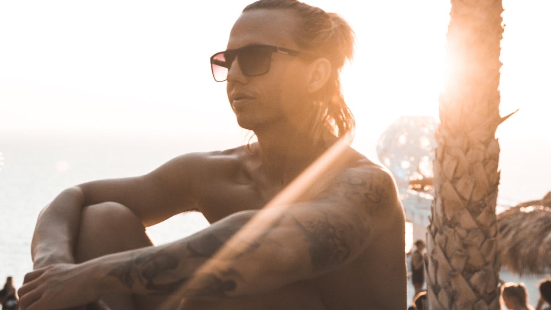 Junge sitzt in der Sonne am Meer