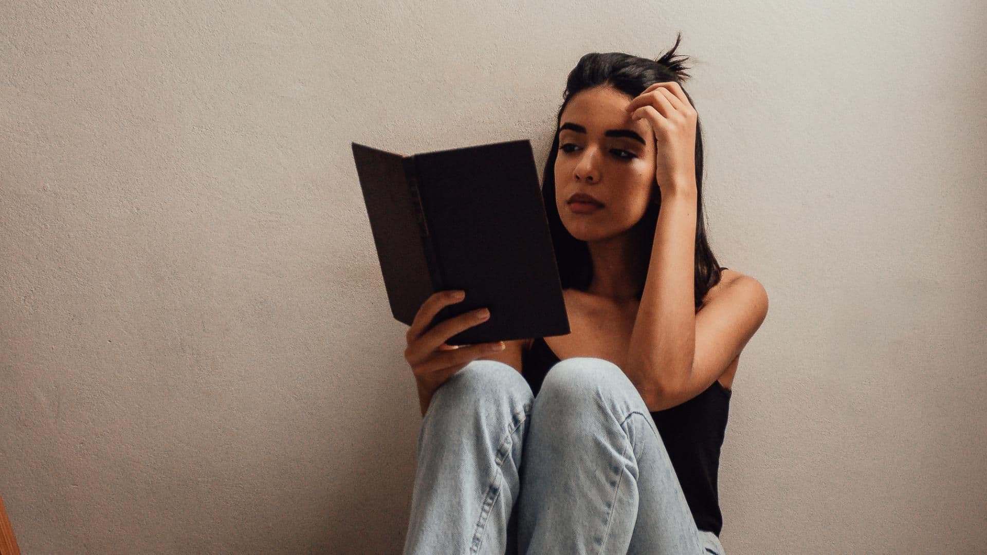 Mädchen sitzt auf dem Boden mit Büchern