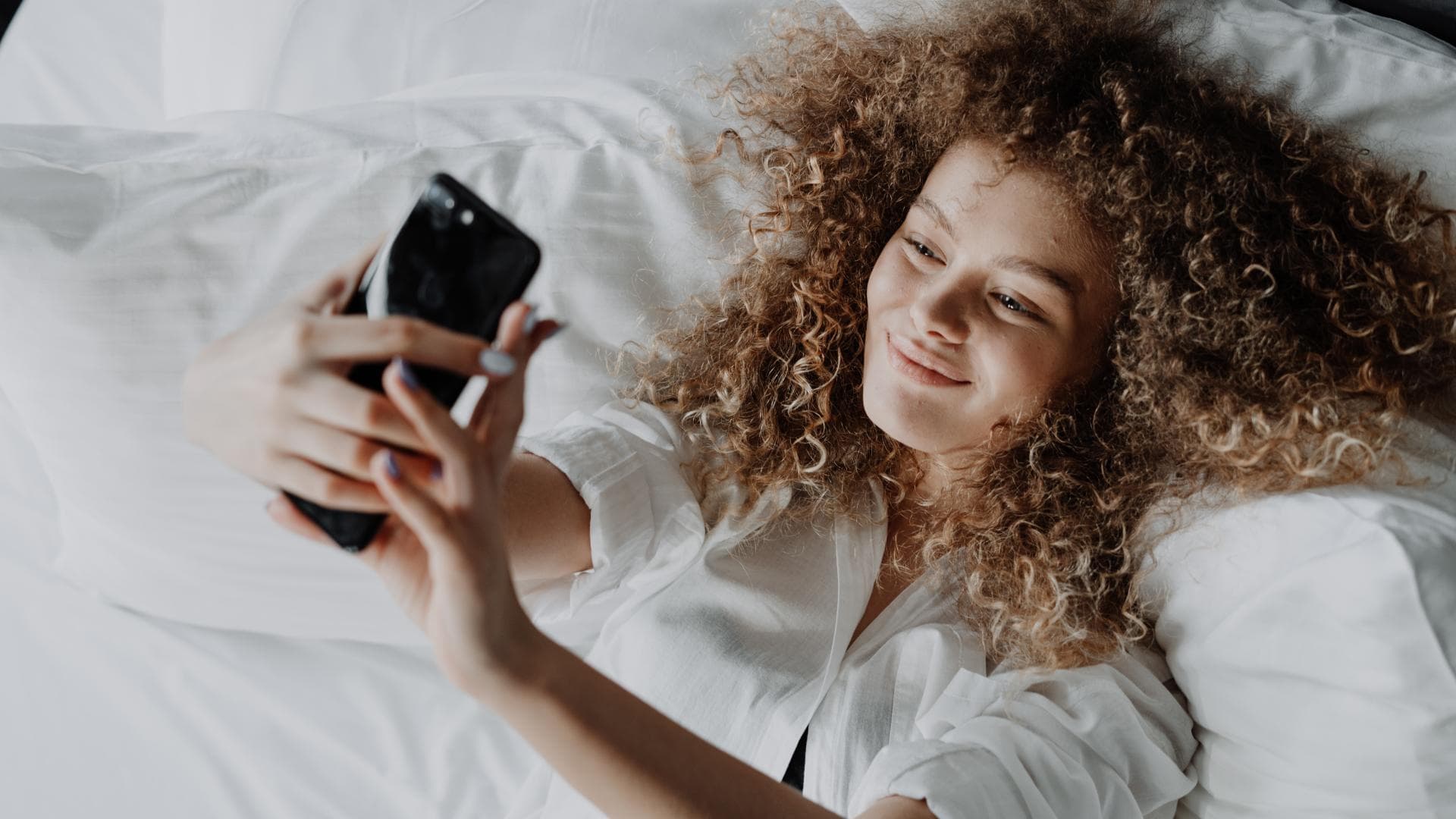 Mädchen im Bett mit Handy