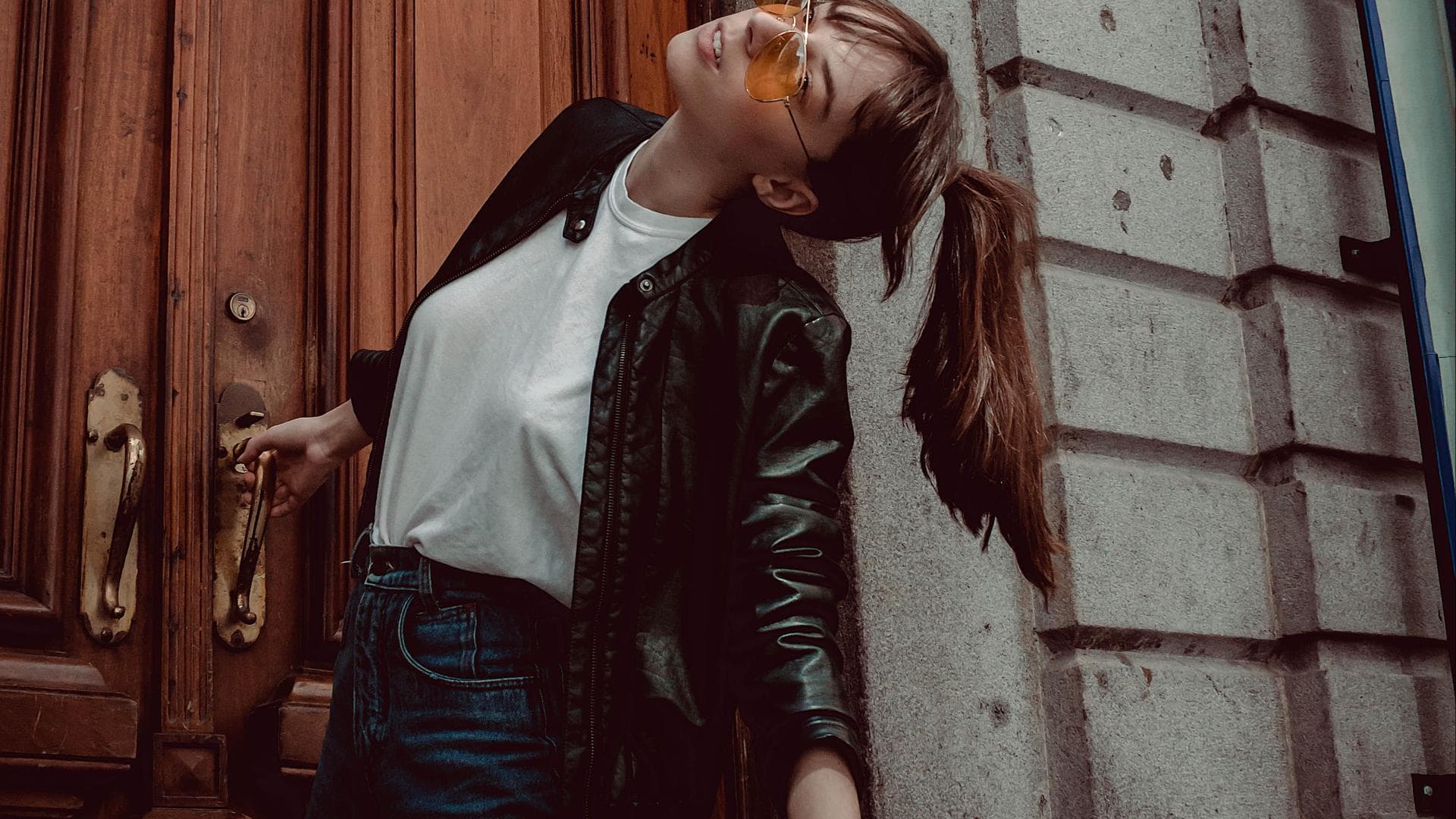 junge Frau in Jeans mit weißem Shirt und Lederjacke