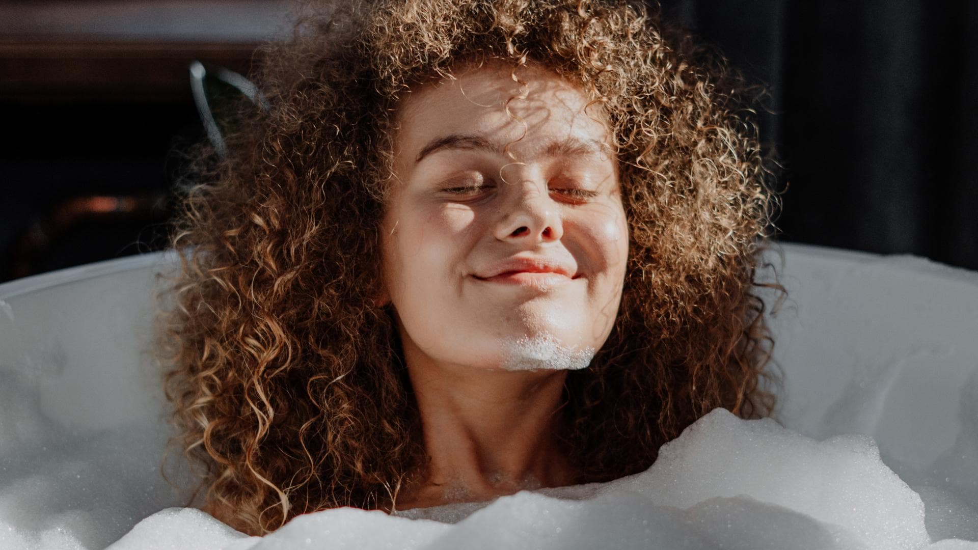 Mädchen mit Locken in der Badewanne