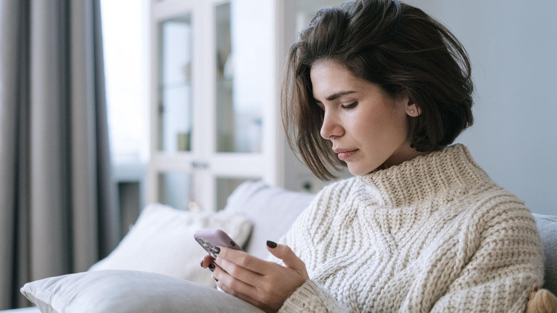 Junge Frau schaut auf Handy Junge Frau schaut auf Handy