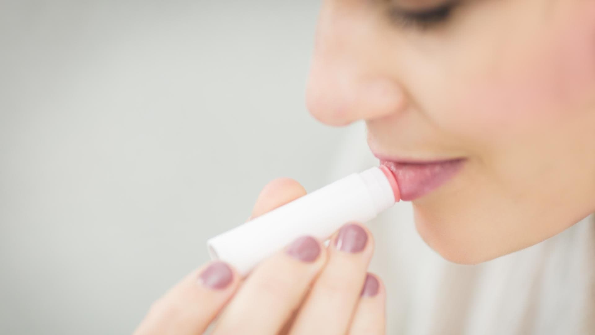 Frau macht sich Lippenbalm auf die Lippen