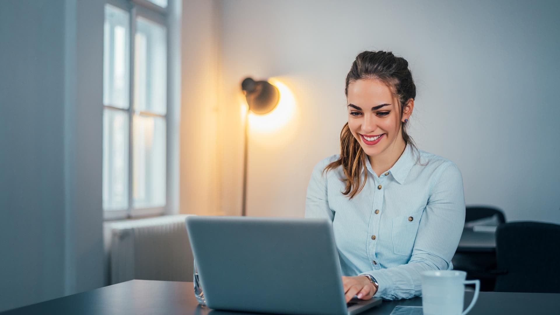 Junge Frau sitzt am Laptop