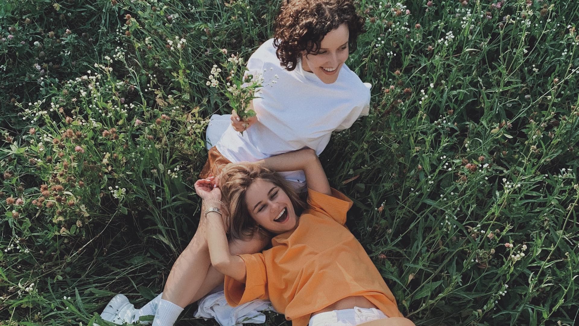 Horoskop der Woche: Zwei Frauen liegen in einem Feld