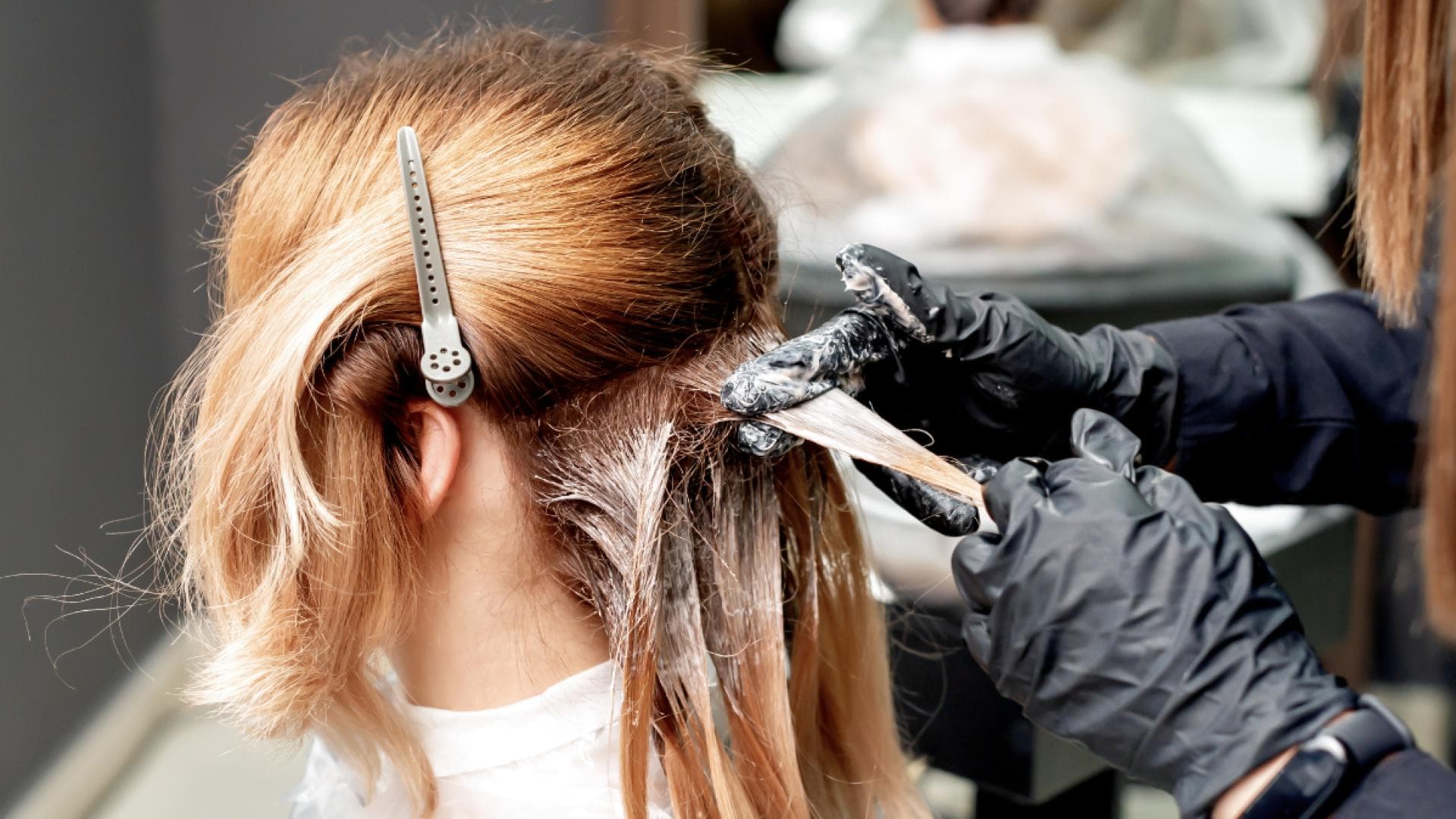 Frau färbt sich beim Friseur die Haare