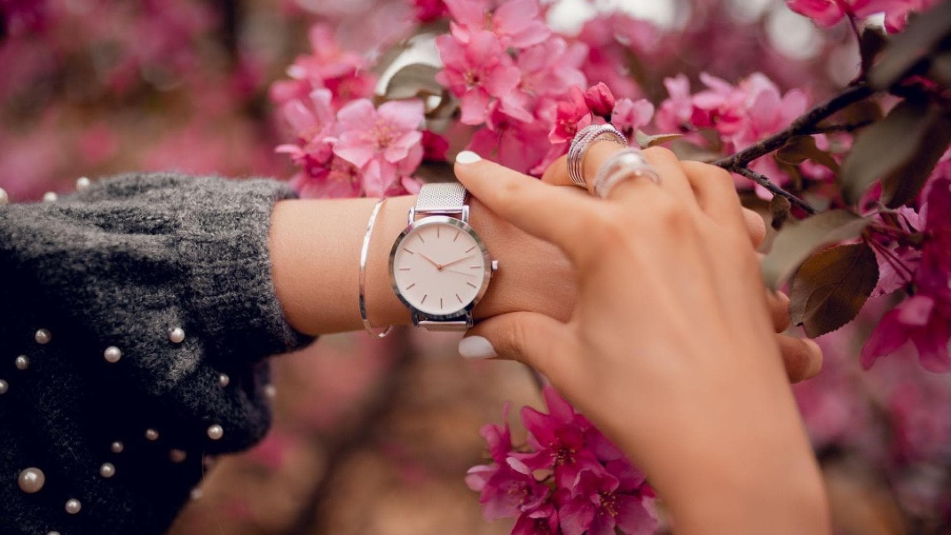 Eine Frau mit einer Uhr und Schmuckstücken in Silber