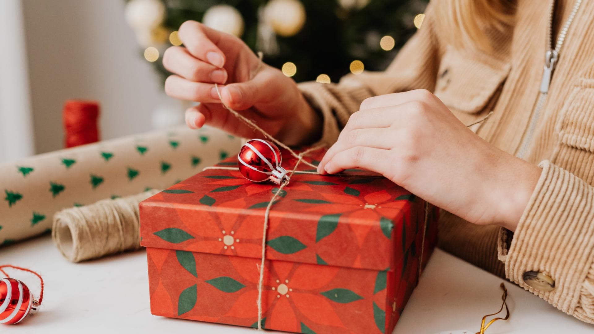 Eine junge Frau packt ein Weihnachtsgeschenk ein