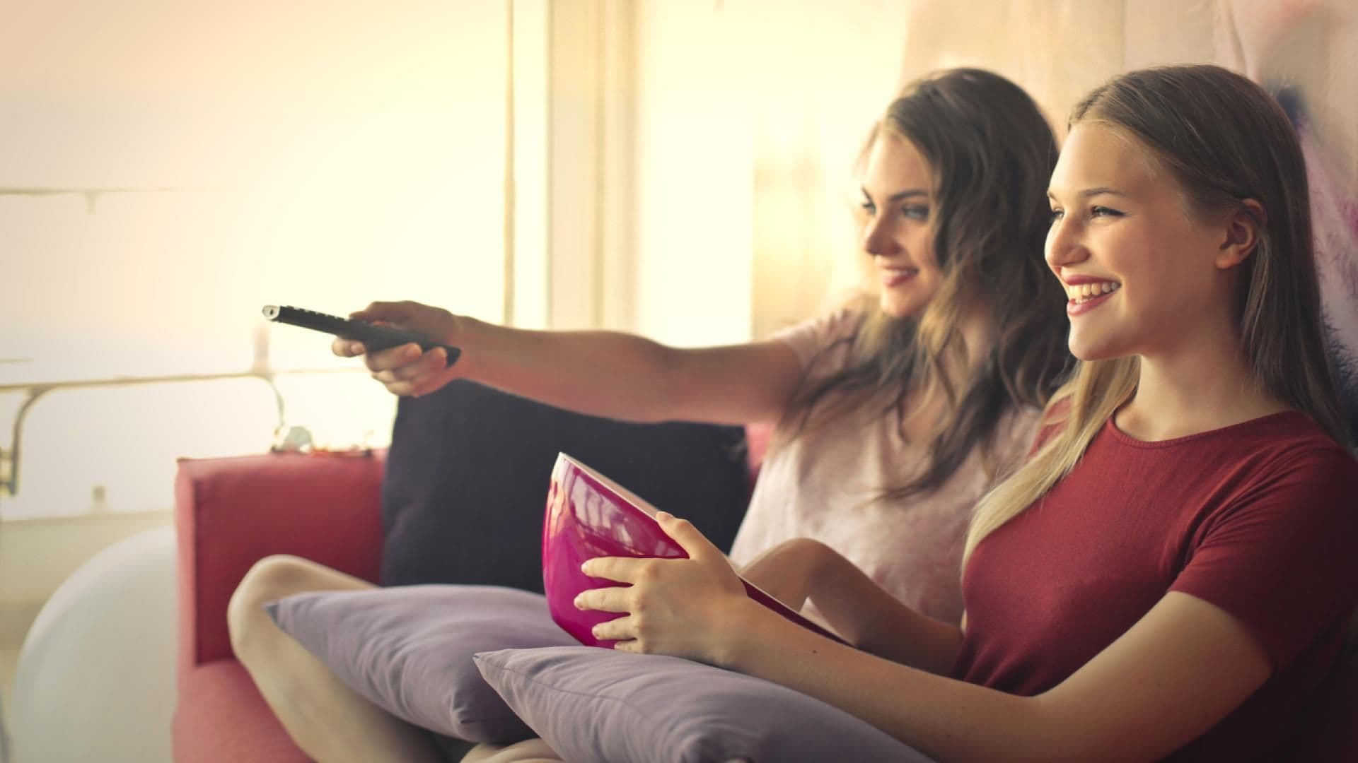 Zwei Freundinnen auf dem Sofa beim Filme schauen