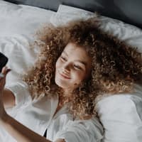 Gute-Nacht-Texte Mädchen im Bett mit Handy