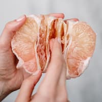 Zwei Hände halten eine Orange