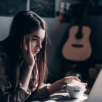 Benching: Mädchen starrt in Laptop und hält eine Tasse in der Hand