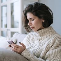 Junge Frau schaut auf Handy