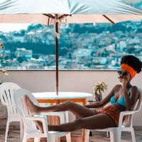 Frau liegt auf dem Balkon im Bikini