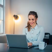 Junge Frau sitzt am Laptop