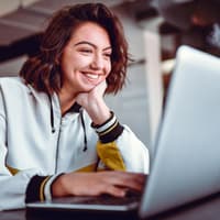 Junges Mädchen sitzt vor einem Laptop