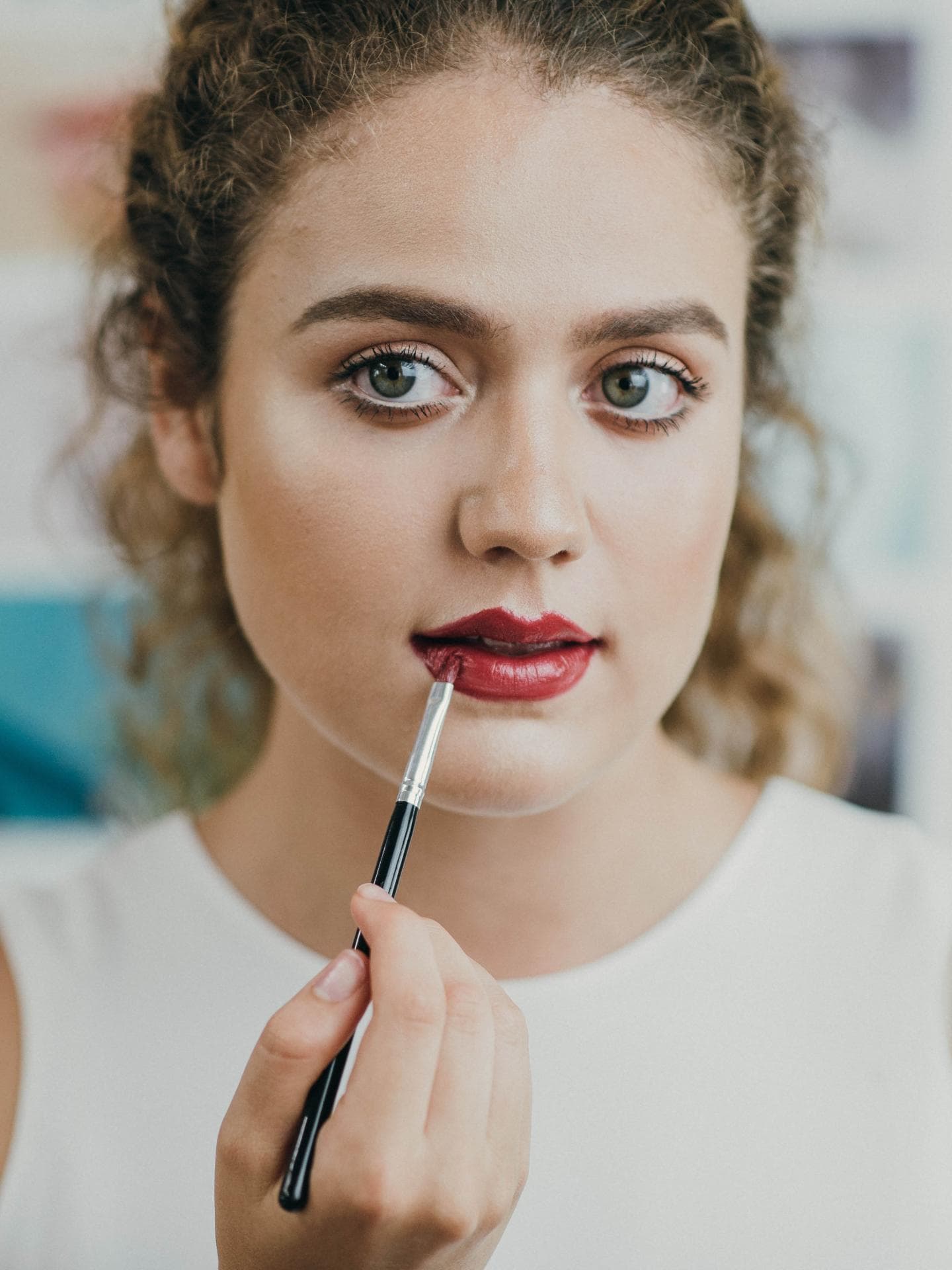 Mädchen malt sich rote Lippen
