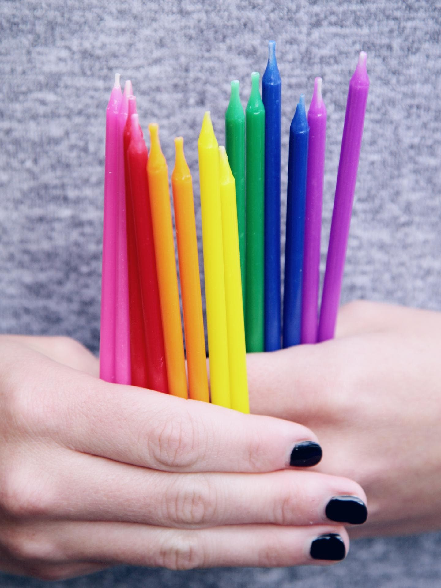 Hände, die bunte Kerzen halten