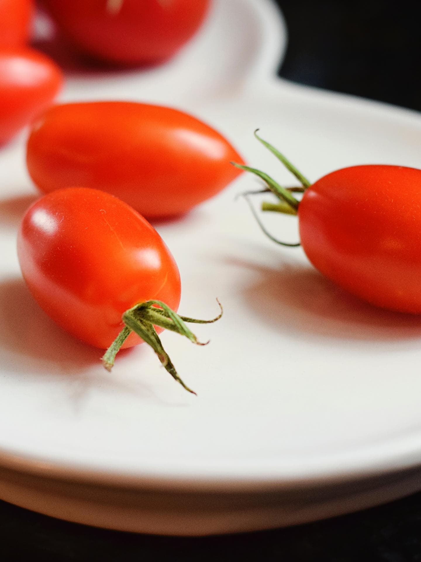 Kleine Tomaten auf Porzellanteller