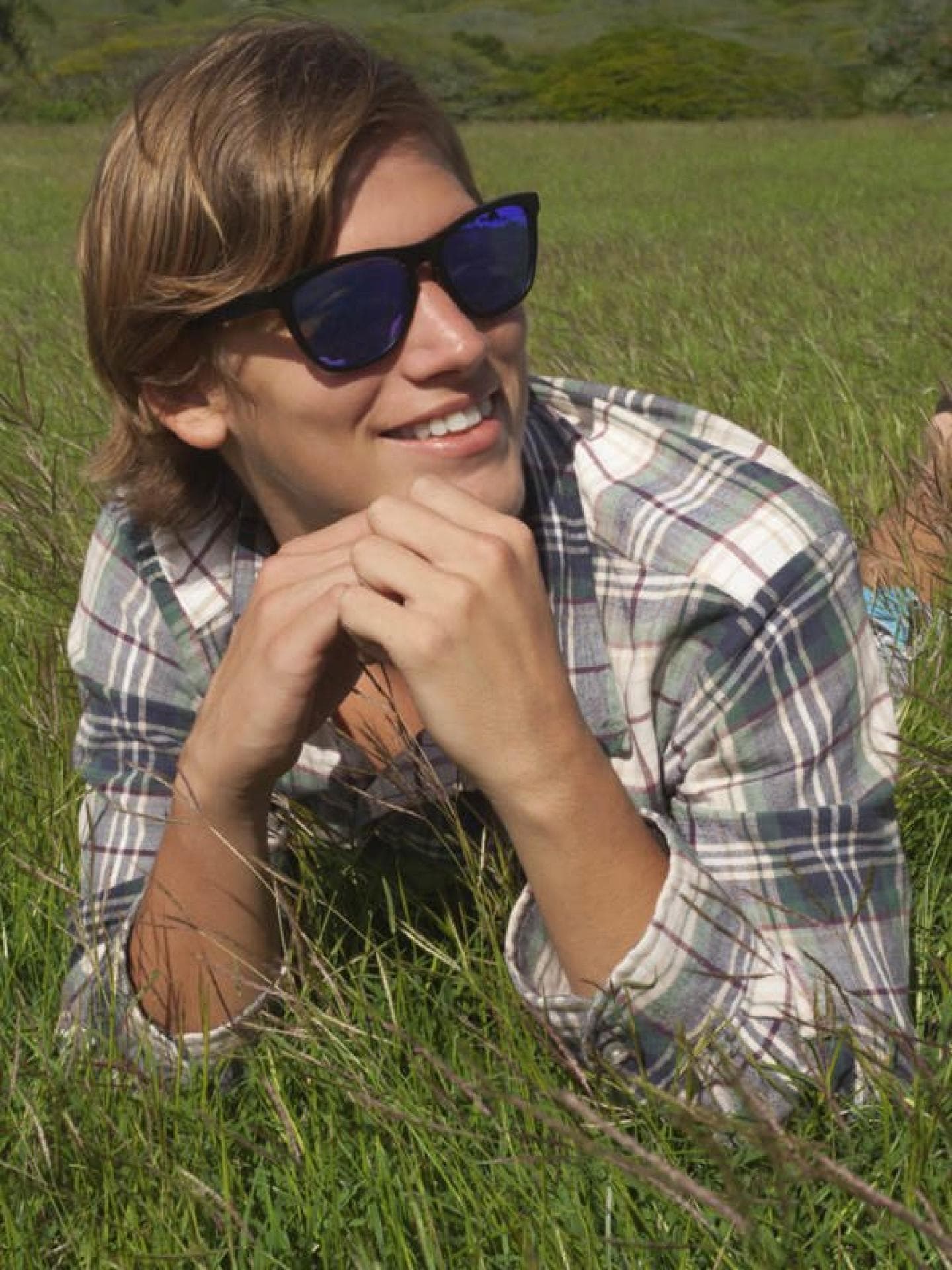 Junge auf einer Wiese mit Sonnenbrille