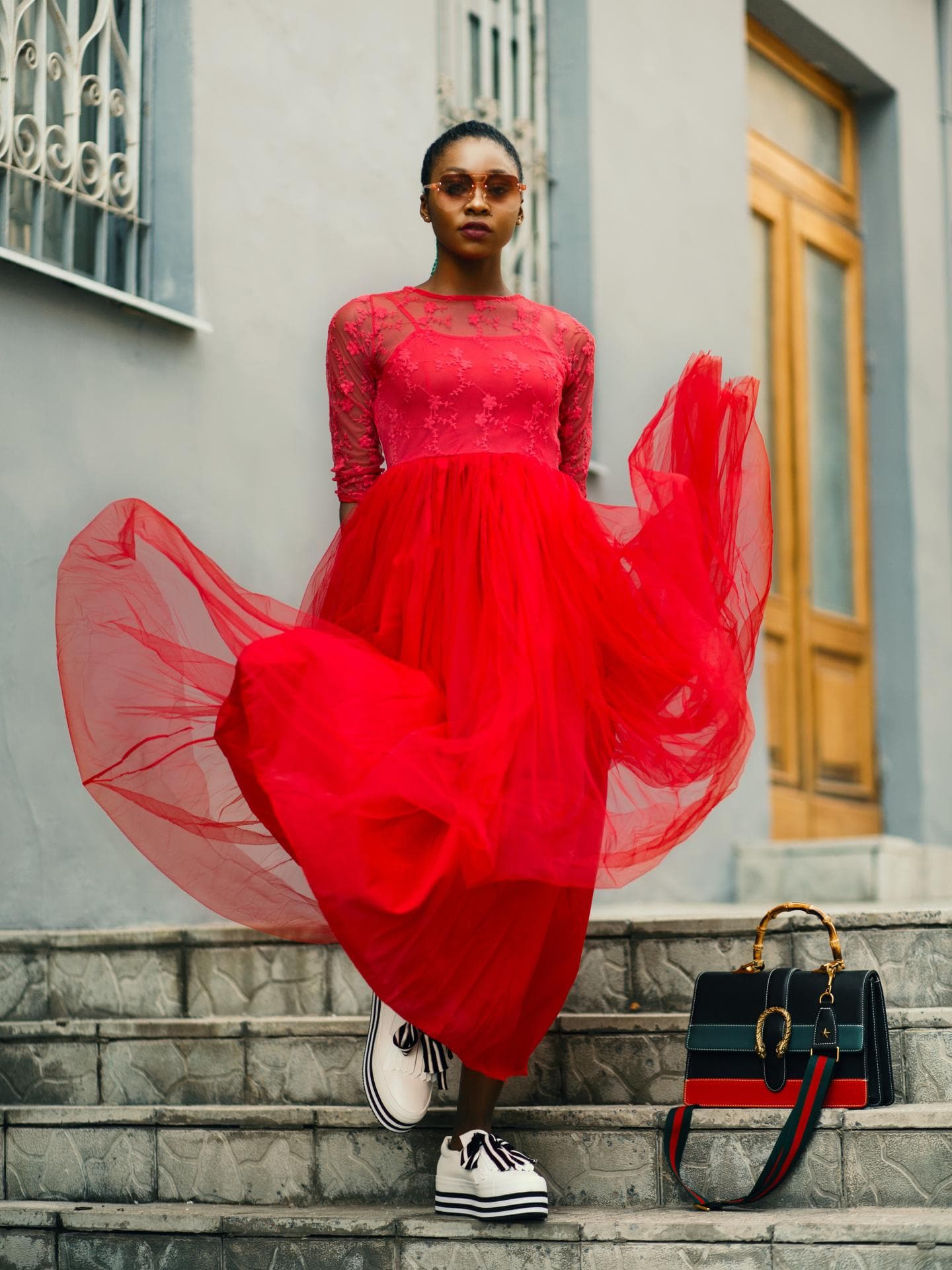 Mädchen im roten Kleid mit Sneakers