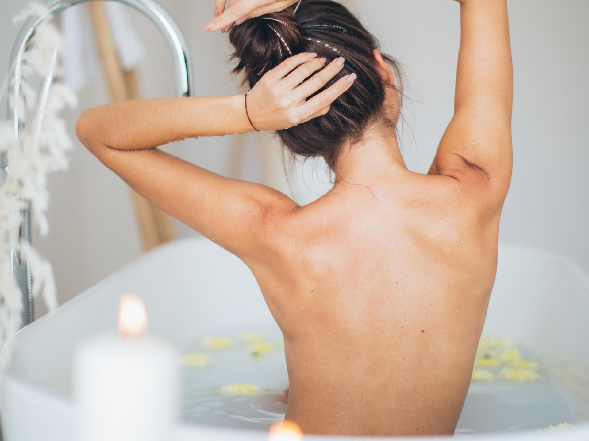 körperpeeling selber machen Junge Frau in Badewanne Kerzenschein