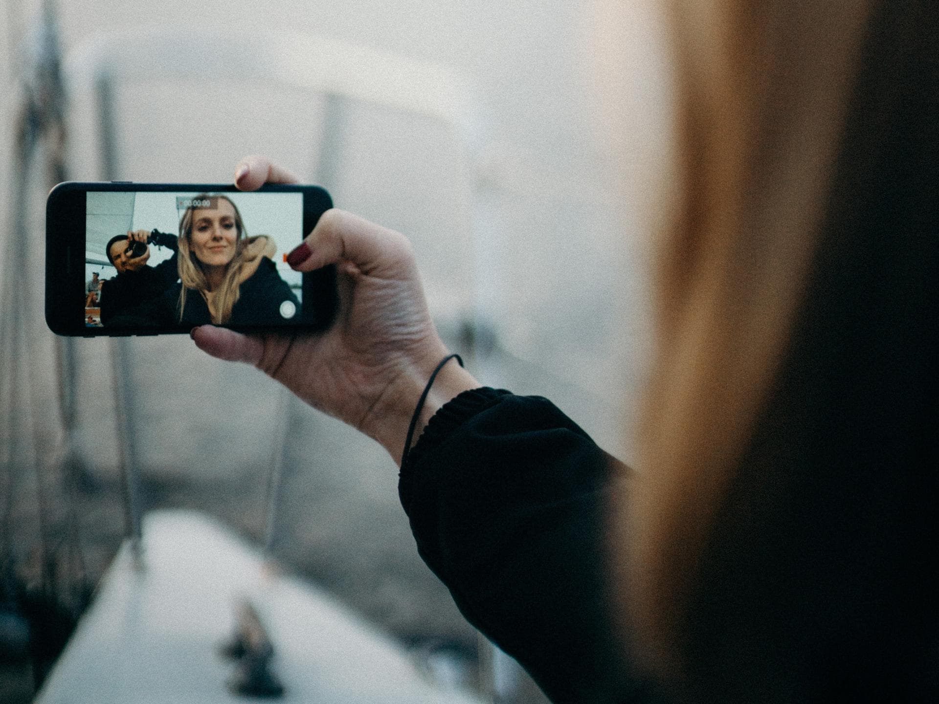 Mädchen hält Handy in der Hand und filmt sich