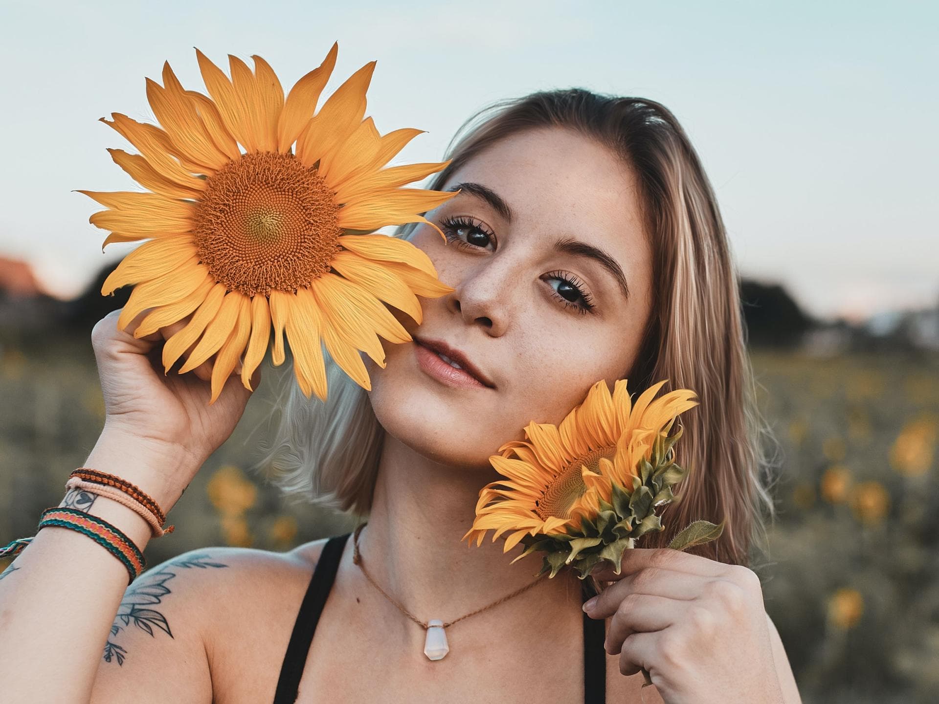 Horoskop Mädchen auf einem Feld mit gelber Blume in der Hand