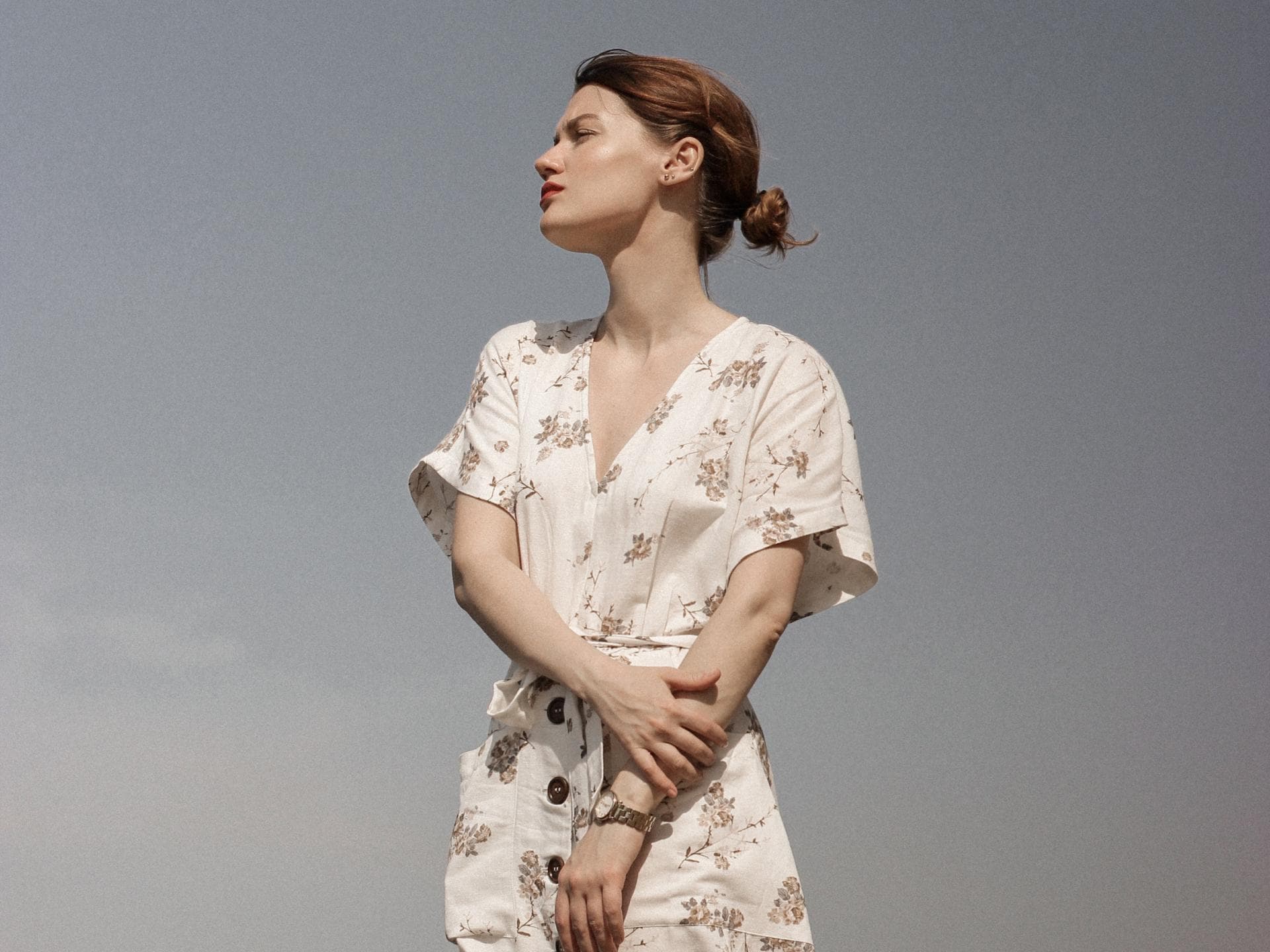 Mädchen im geblümten Kleid vor blauem Himmel