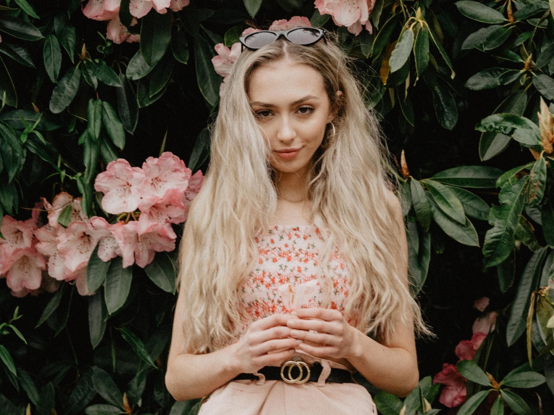 H&M Oberteil Sommertrend Mädchen blonde Haare vor Blumenbusch