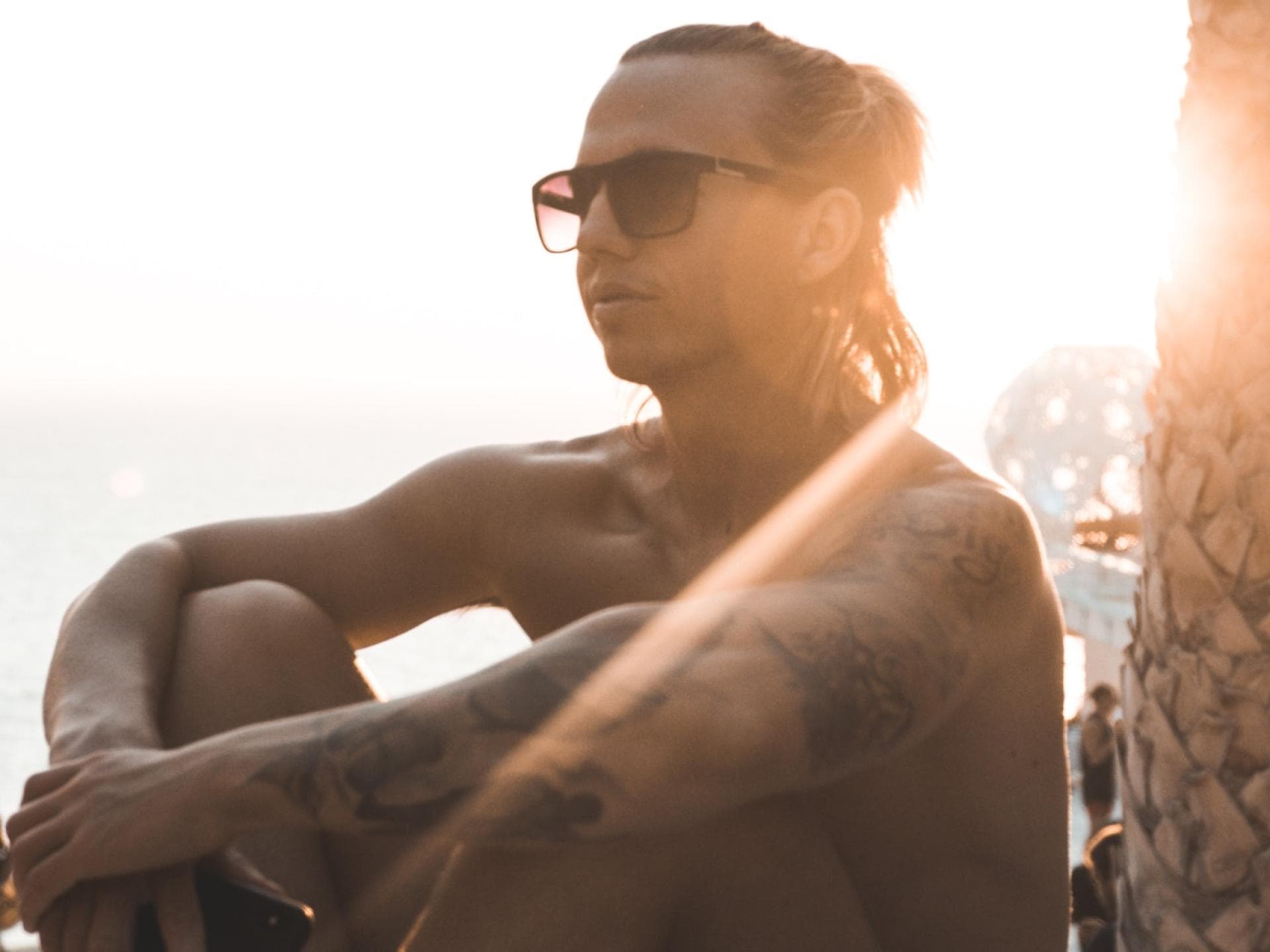 Junge sitzt in der Sonne am Meer