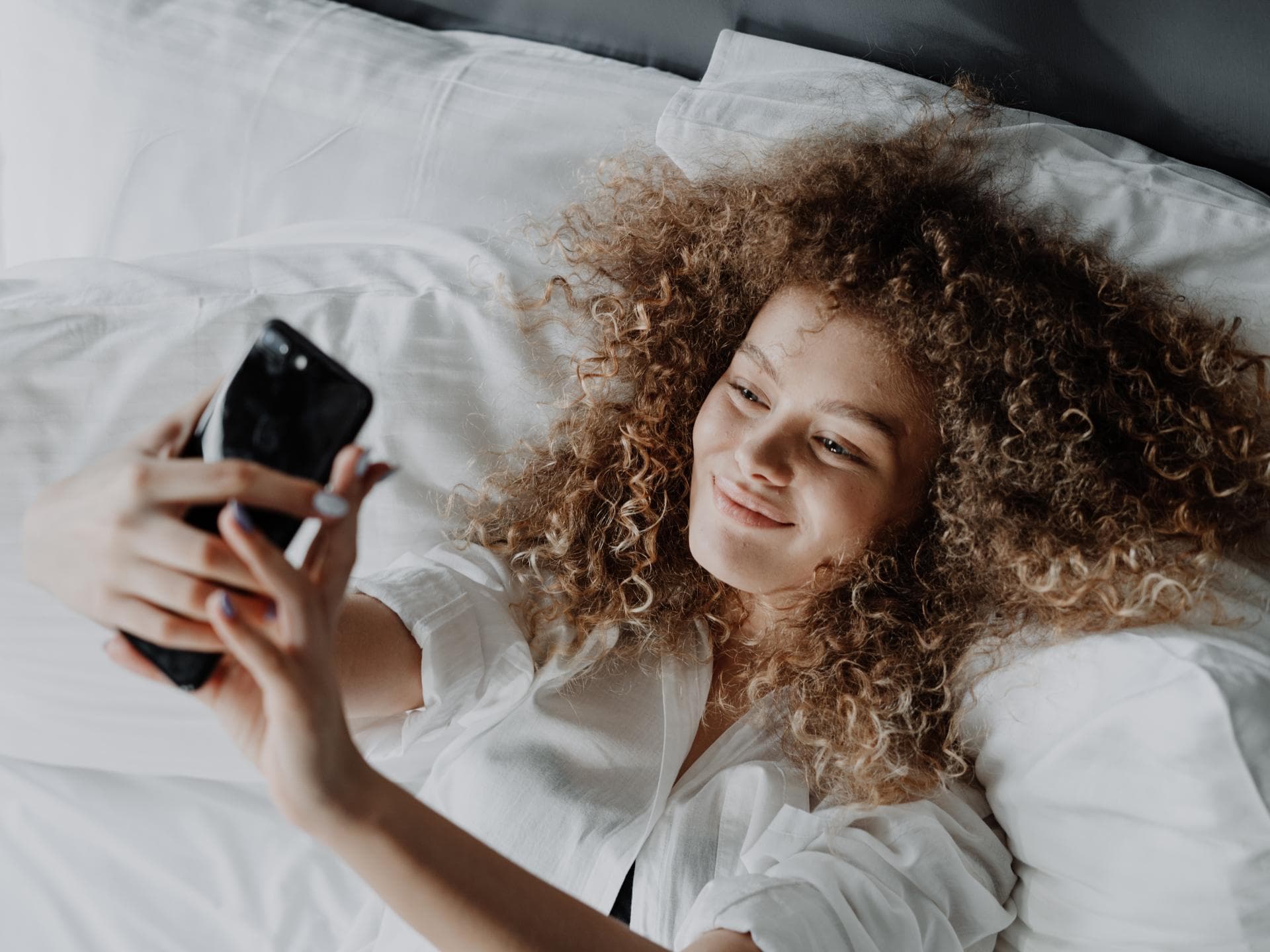 Mädchen im Bett mit Handy