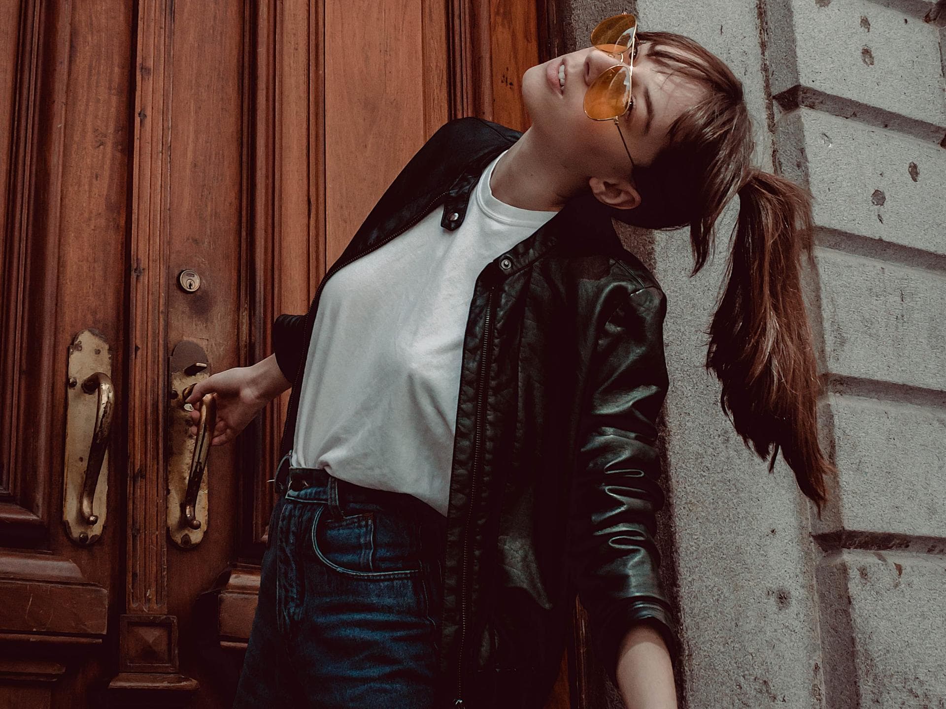 3 Basic Teile als Modetrend junge Frau in Jeans mit weißem Shirt und Lederjacke