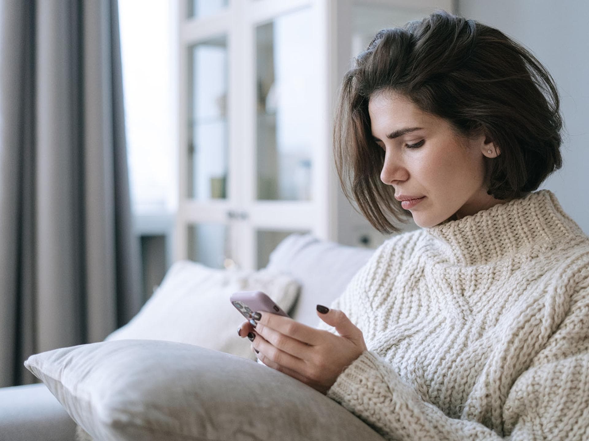Junge Frau schaut auf Handy Junge Frau schaut auf Handy
