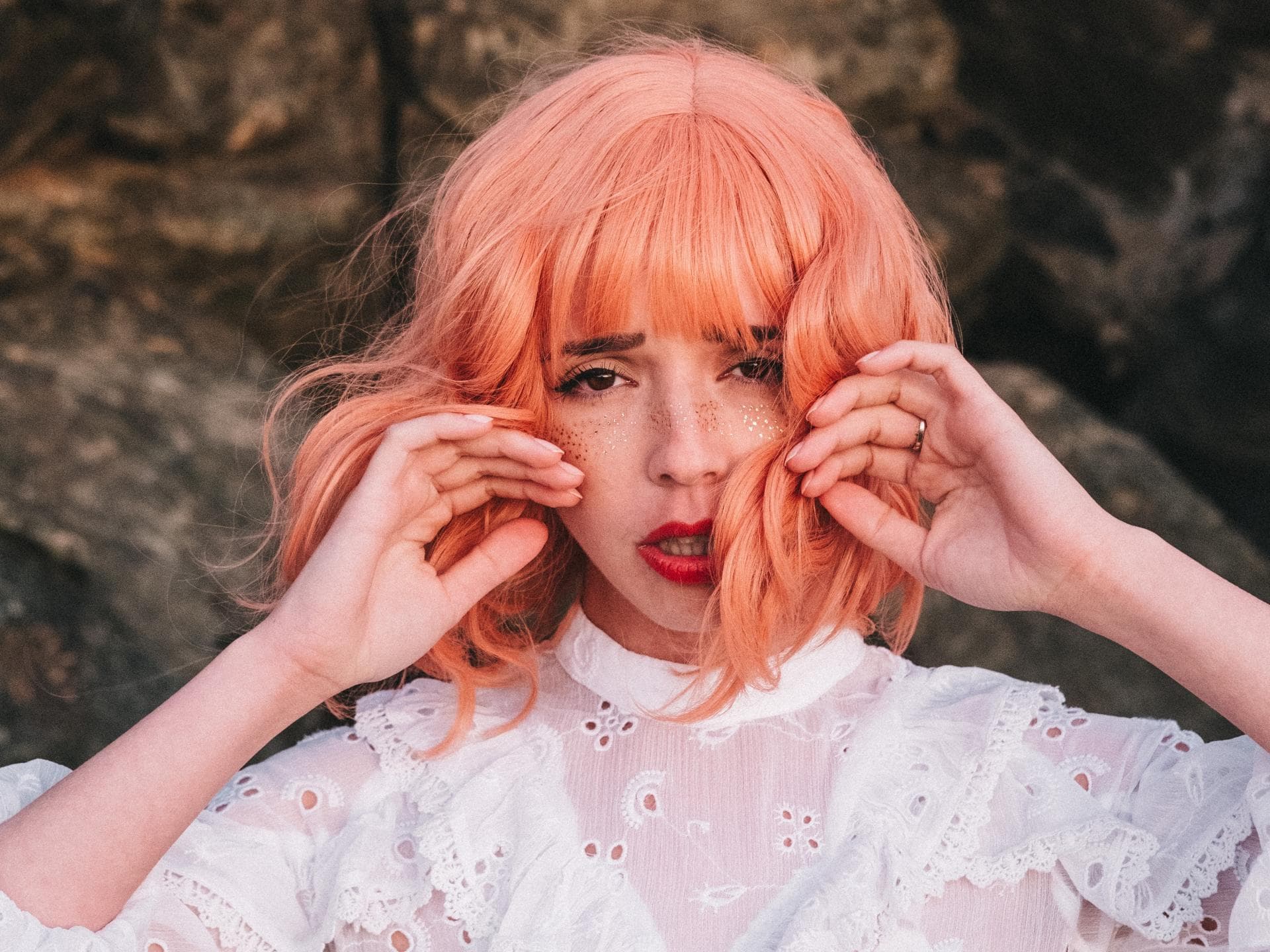Wochen-Horoskop Frau mit rosa Haaren und Glitzer im Gesicht