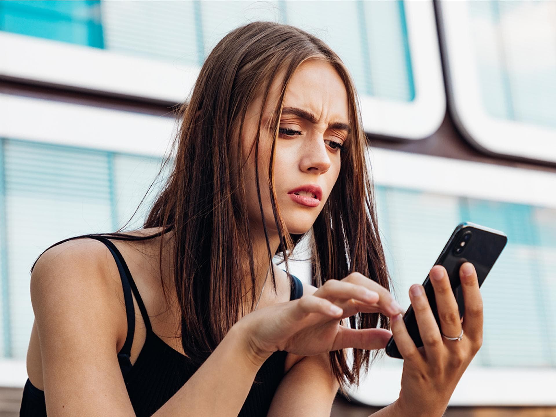 Frau schaut verwirrt auf Handy