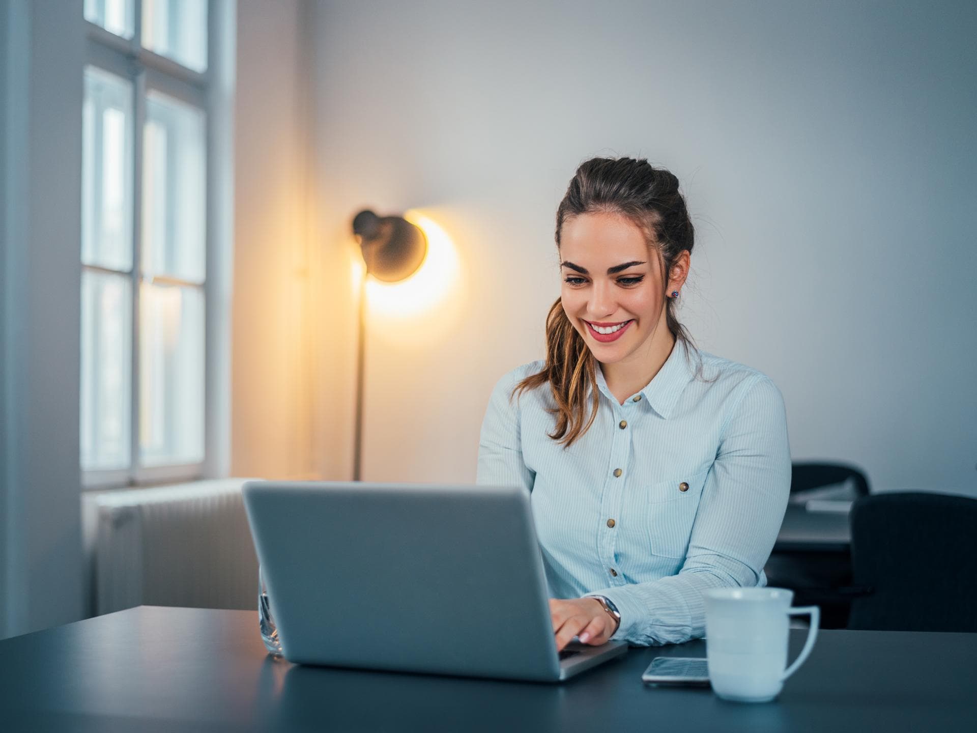 Junge Frau sitzt am Laptop