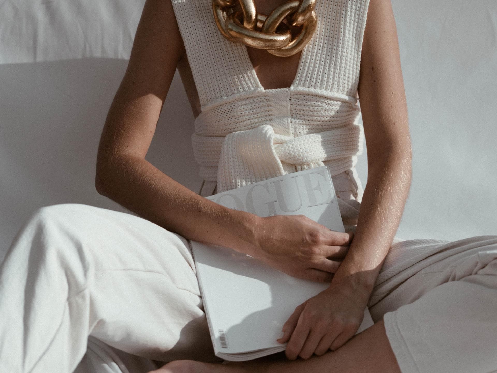 Horoskop: Frau mit weißem Outfit und Goldkette