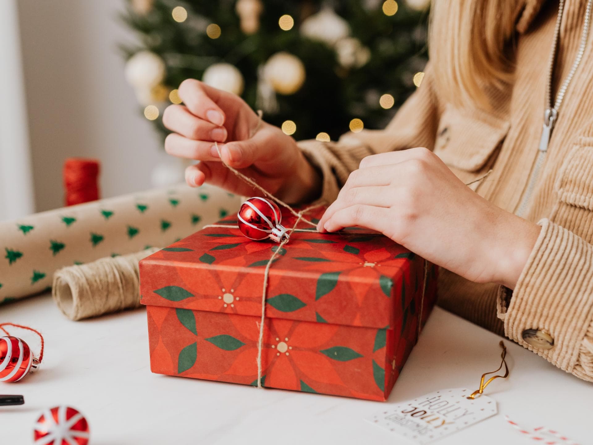 Eine junge Frau packt ein Weihnachtsgeschenk ein