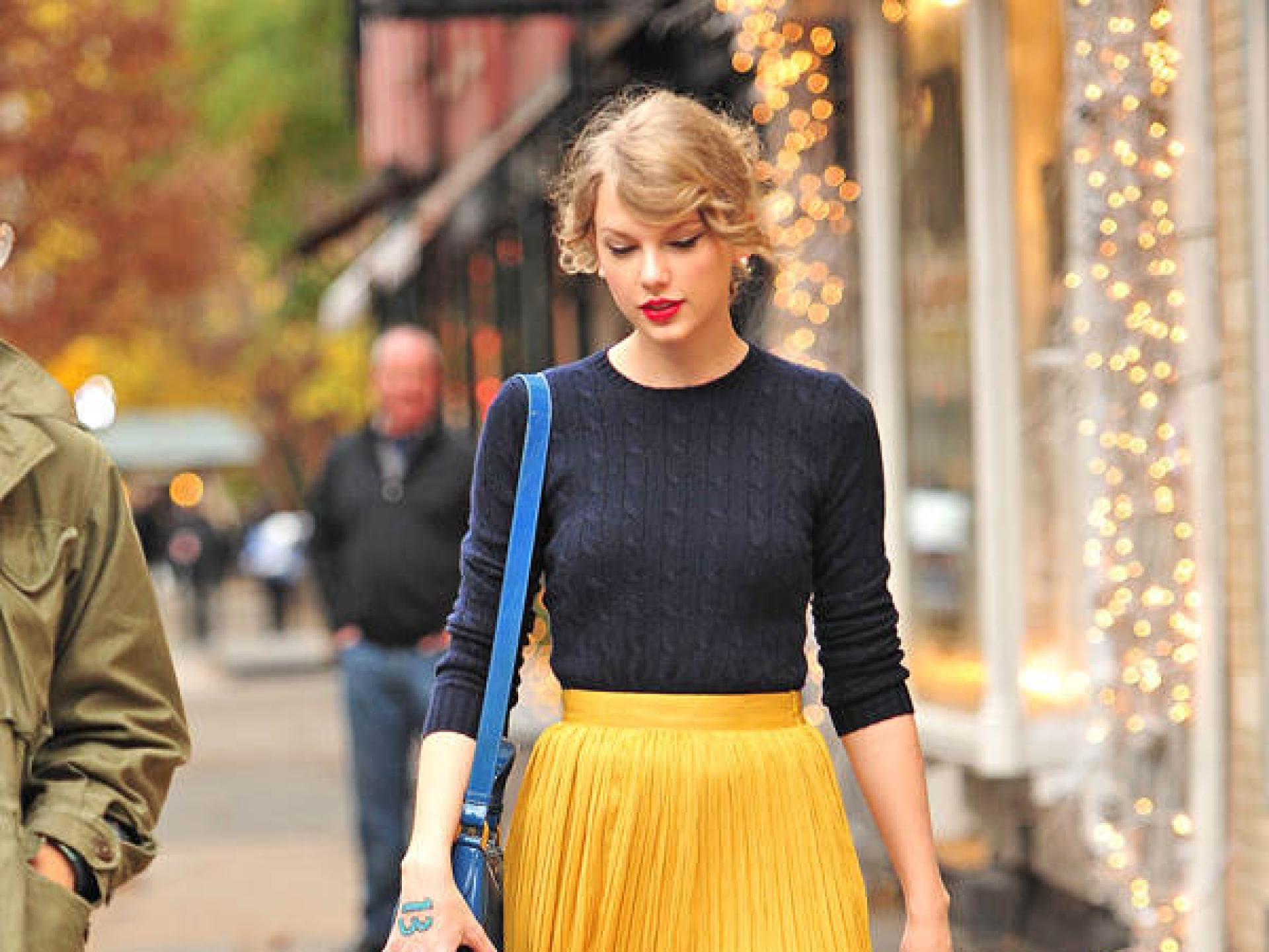 Taylor Swift mit gelbem Rock und roten Ballerinas Taylor Swift mit gelbem Rock und roten Ballerinas