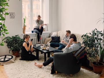 Wahrheit oder Pflicht: Freunde sitzen im Wohnzimmer und spielen