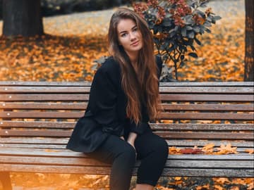 Mädchen auf Parkbank mit langen Haaren im Herbst