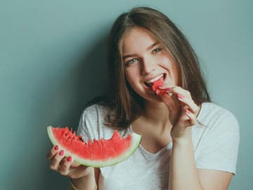 Mädchen isst Wassermelonet, denn sie ist Vegetarier