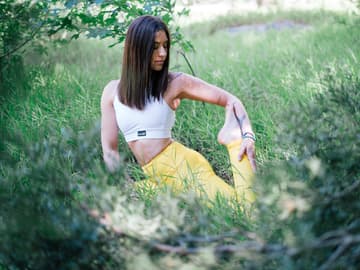 Mädchen auf einer Wiese macht Yoga