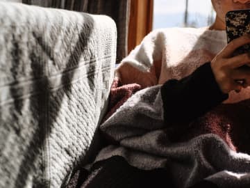 Mädchen auf Sofa mit Handy