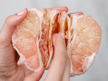 Zwei Hände halten eine Orange