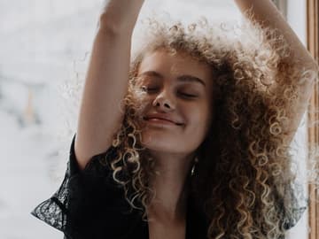 Mädchen mit Locken vor einem Fenster