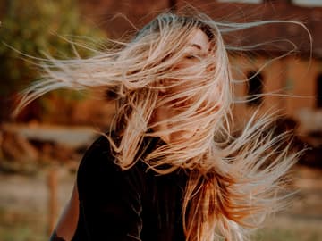 Mädchen mit langen Haaren im Gesicht