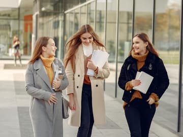 Öffnung der Schulen und Kitas: Drei Mädchen mit Papieren und Büchern in der Hand gehen